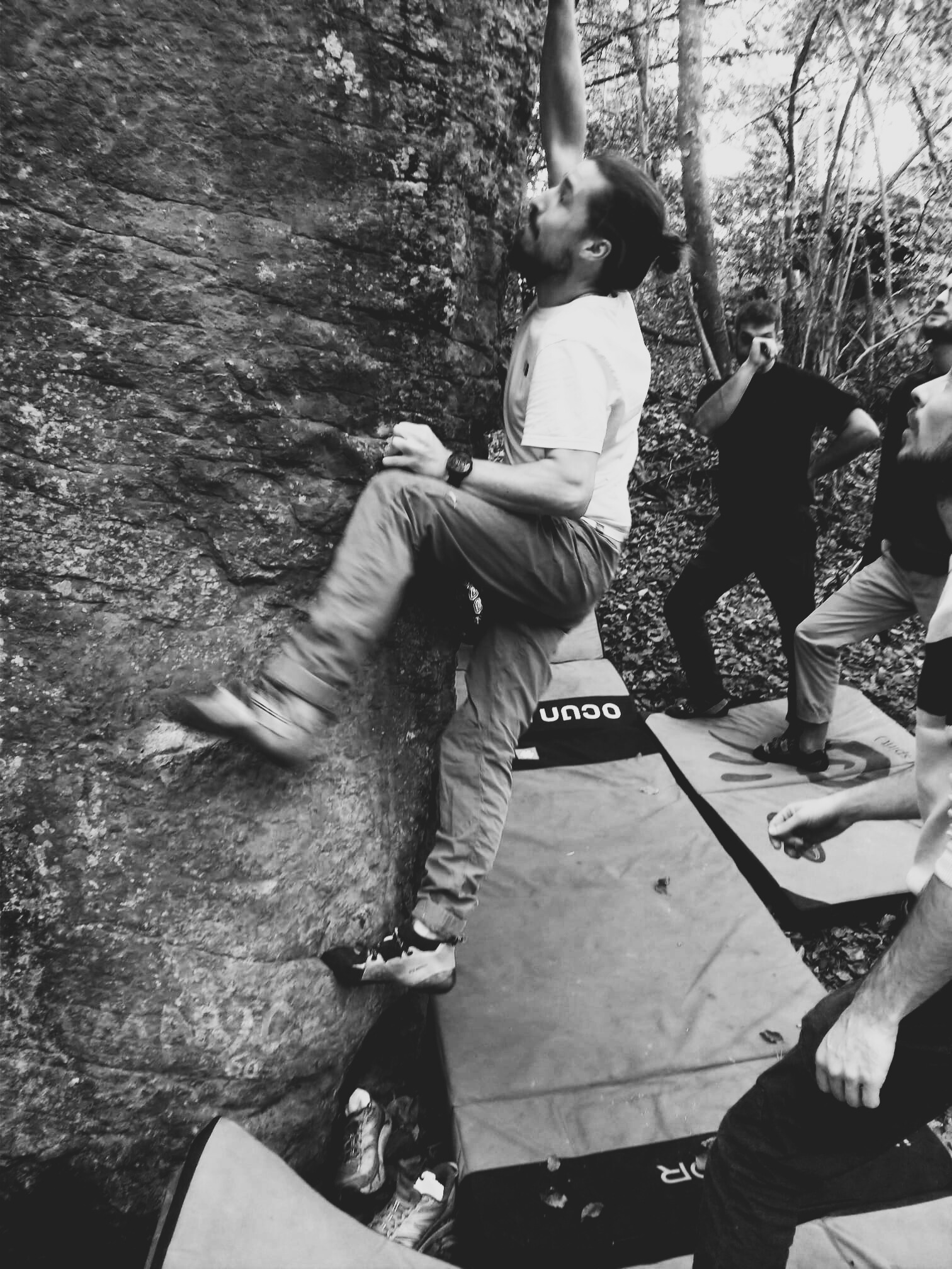 Une photo de Julien qui fait de l'escalade en bloc en forêt.